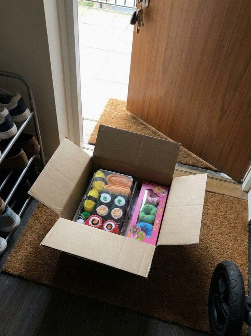 Het pakket met de sushi- en de donutdoos op de deurmat (door AI gegenereerde illustratie)